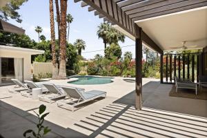 Un patio con tumbonas y una piscina. en Hugh Kaptur Hideaway Villa, en Palm Desert