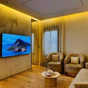 un salon avec une télévision à écran plat sur un mur dans l'établissement Spacious and Modern Apartment for Rent in Ergah, Riyadh, à Riyad