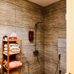 une salle de bain avec douche et une étagère avec serviettes dans l'établissement Spacious and Modern Apartment for Rent in Ergah, Riyadh, à Riyad