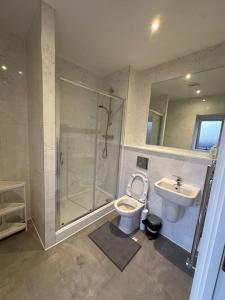 a bathroom with a shower and a toilet and a sink at Large Ensuite Room in Manchester with Free Parking in Manchester