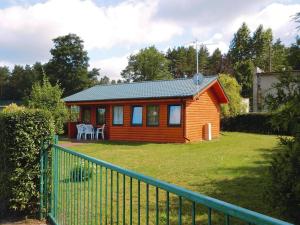 mały domek na podwórku z płotem w obiekcie Holiday home by the lake, Rosnowo w mieście Rosnowo