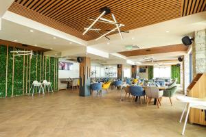 a dining room with tables and chairs and plants at Lavalliere Hotel & Villas in Sarnitsa