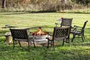 a group of chairs around a fire pit in a field at Riverfront w Deck Grill Fire pit & Climbing Wall in Hedgesville