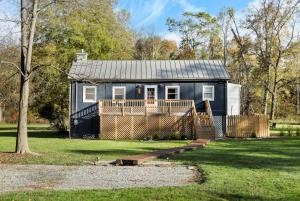 a blue house with a deck in a yard at Riverfront w Deck Grill Fire pit & Climbing Wall in Hedgesville