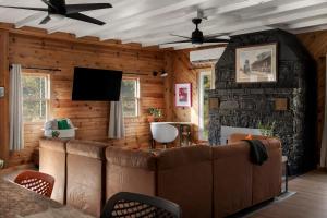 a living room with a couch and a stone wall at Riverfront w Deck Grill Fire pit & Climbing Wall in Hedgesville +56 photos