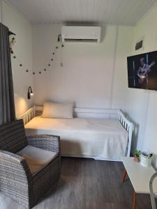 a small bedroom with a bed and a chair at PIRIA in Playa Hermosa