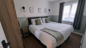 Un dormitorio con una cama grande con sábanas y almohadas blancas. en 2 Bedroom apartment in Brean, en Brean