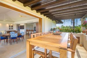 a dining room with a wooden table and chairs at PH Condo Lago in El Encanto -Lake View Penthouse with Pool Punta Mita in Punta Mita