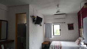 a small bedroom with a bed and a window at Hotel Gutierrez in Celestún