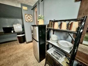 a kitchen with a shelf with plates and a refrigerator at Schillhaus Lvl 3 in Louisville +5 photos