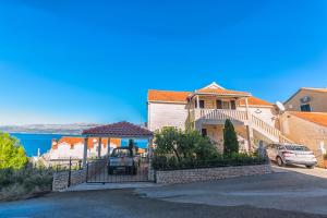 een huis met een tuinhuisje in een straat bij Apartments Paco in Postira