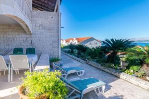 een terras met tafels en stoelen en uitzicht op de oceaan bij Apartments Paco in Postira