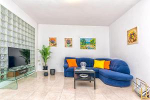 een woonkamer met een blauwe bank en een tv bij Apartments Paco in Postira +45 foto's
