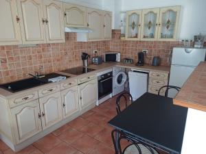 a kitchen with white cabinets and a table with chairs at Maison - Moulins 03000 in Moulins