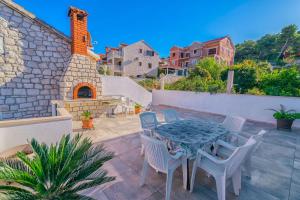 a patio with a table and chairs and a building at Apartments Terrace in Postira