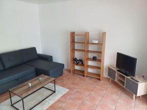 a living room with a blue couch and a tv at Maison - Moulins 03000 in Moulins