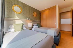 een slaapkamer met twee bedden en een spiegel bij Brick apartment two blocks from plaza Rio de Janeiro Roma in Mexico-Stad