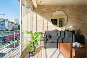 een woonkamer met een bank op een balkon bij Brick apartment two blocks from plaza Rio de Janeiro Roma in Mexico-Stad