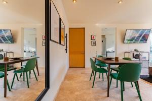 een eetkamer met groene stoelen en een spiegel bij Brick apartment two blocks from plaza Rio de Janeiro Roma in Mexico-Stad +16 foto's