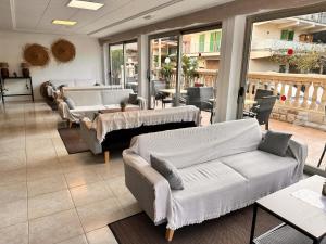 salon z kanapami, stołami i oknami w obiekcie Hotel Selva Arenal w El Arenal