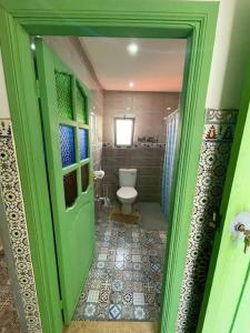 a green door leading to a bathroom with a toilet at Marrakech Premium Dar Aicha in El Gouassem +9 photos