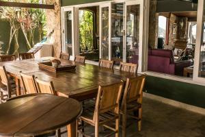 a dining room with a wooden table and chairs at Casa pe na areia em Buzios in Búzios