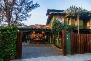 a house with a wooden gate and a fence at Casa pe na areia em Buzios in Búzios