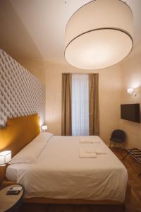 een slaapkamer met een groot bed en een grote lamp bij Librai suite in Napels