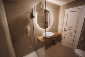 een badkamer met wastafel en douche met spiegel bij Librai suite in Napels