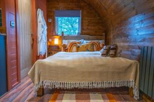 une chambre avec un lit dans une cabane en bois dans l'établissement Bonnie Brae - (Luxury Pod), à Portpatrick