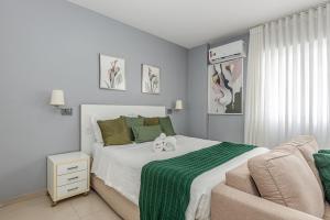 a bedroom with a large bed and a couch at Alphaville-Industrial com cozinha-piscina e academia-500mega in Barueri