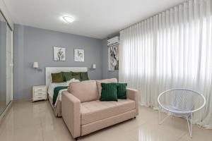 a bedroom with a bed and a couch and a chair at Alphaville-Industrial com cozinha-piscina e academia-500mega in Barueri