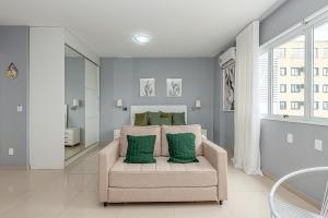 a living room with a chair with two green pillows at Alphaville-Industrial com cozinha-piscina e academia-500mega in Barueri