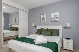 a bedroom with a large white bed and a mirror at Alphaville-Industrial com cozinha-piscina e academia-500mega in Barueri