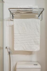 a towel rack above a toilet in a bathroom at Alphaville-Industrial com cozinha-piscina e academia-500mega in Barueri