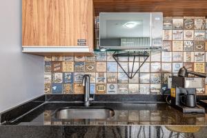 a kitchen with a sink and a microwave at Alphaville-Industrial com cozinha-piscina e academia-500mega in Barueri