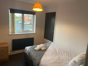 un dormitorio con una cama y una ventana en Tipton 2 Bedroomed long Stay Pad van or car free parking, en Ocker Hill