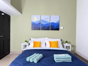 una camera da letto con un letto con lenzuola blu e cuscini arancioni di Coastal Haus, 5 Min to Beach, AC 4 BHK, Foosball Table a Kappil