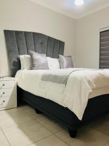 - un grand lit avec une grande tête de lit dans une chambre dans l'établissement The Blyde 1471, à Pretoria 7 autres photos