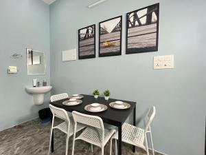 una sala da pranzo con tavolo nero e sedie bianche di Coastal Haus, 5 Min to Beach, AC 4 BHK, Foosball Table a Kappil Altre 22 foto