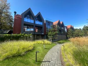 een huis met een bakstenen pad ervoor bij Hill Apartment in Palanga