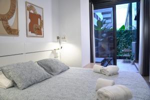 バレンシアにあるEspectacular Loft Piscina y Terraza - Roig Arena - Las Ciencias - Ruzafa - Valencia Centroのベッドとタオル2枚のある寝室