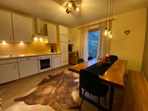 Una cocina con una mesa de madera y un comedor. en Chalet Panoramablick Garten Sauna, en Rohrberg