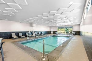 a swimming pool with chairs and tables in a building at Best Western Plus Bolivar Hotel & Suites in Bolivar