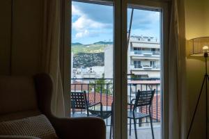 a room with a view of a balcony with chairs at Christina's Cozy Apartment Volos in Volos