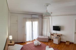 a living room with a bed and a television and a room with at Christina's Cozy Apartment Volos in Volos
