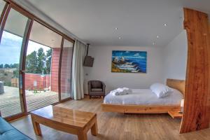 una camera da letto con un letto e una grande finestra di Ruka Lobos a Pichilemu