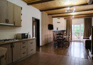 a kitchen and living room with wooden ceilings at Мигово Гражда in Migovo