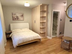 a bedroom with a bed and a book shelf at Central London Studio Apartment in London