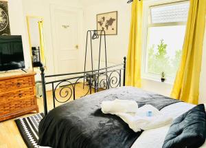 a bedroom with a bed and a television and a window at Taswell Road in Portsmouth